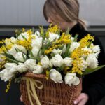 Весенний букет из белых тюльпанов и яркой мимозы в плетёной корзине